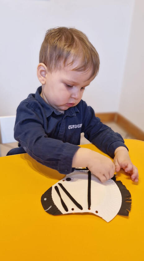 Boy creating zebra stripes during activities at Mariposa Nursery