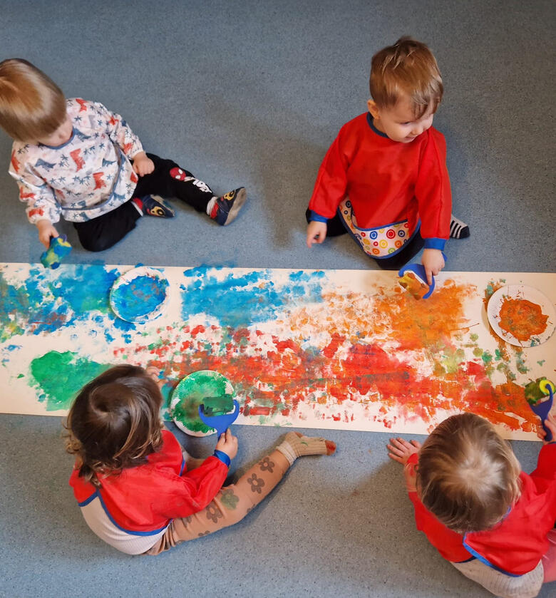 Untitled Children painting on the floor in the room at Mariposa Nursery