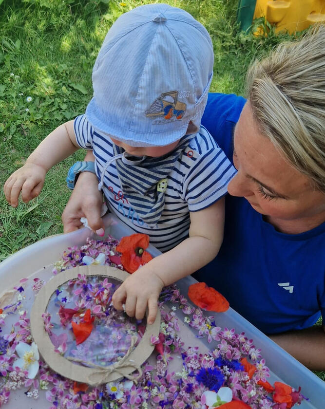 Child creating an art project with flowers in the garden of Mariposa Nursery